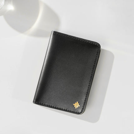 Black leather wallet with a brand logo on a white surface