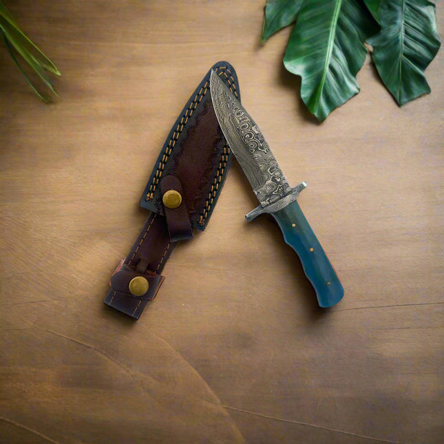 Decorative knife with a blue handle and detailed blade on a leather sheath against a white background